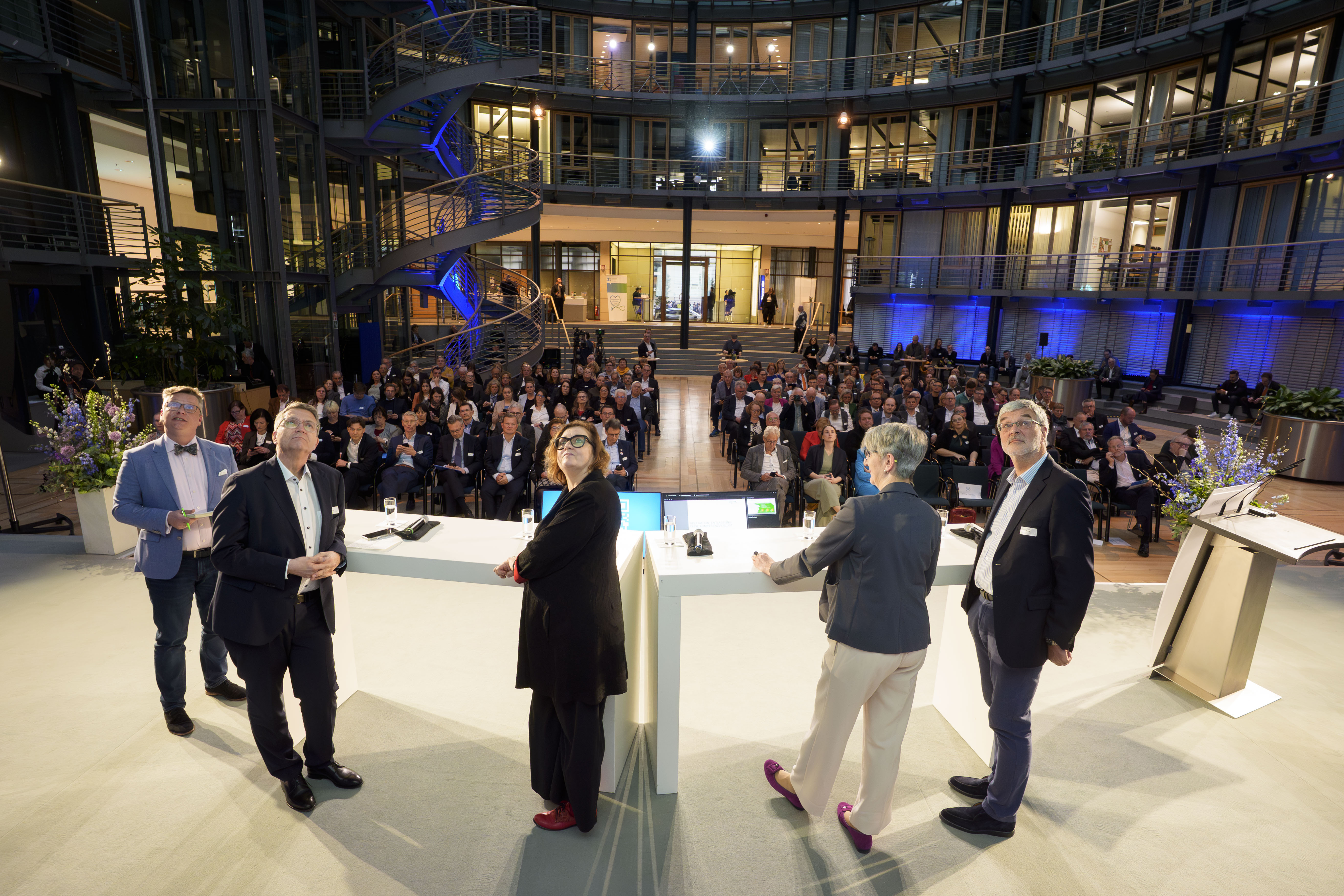 Podiumsdiskussion mit Publikum im Hintergrund