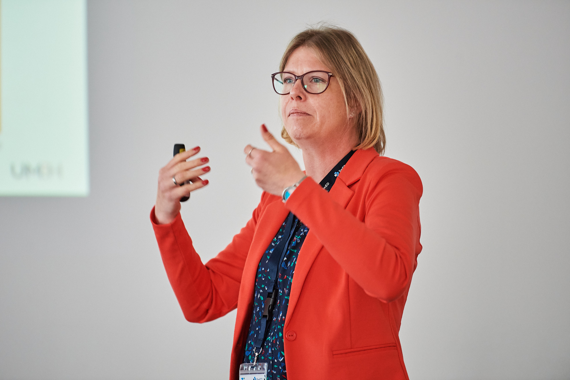 Eine Frau steht auf der Bühne und gestikuliert.
