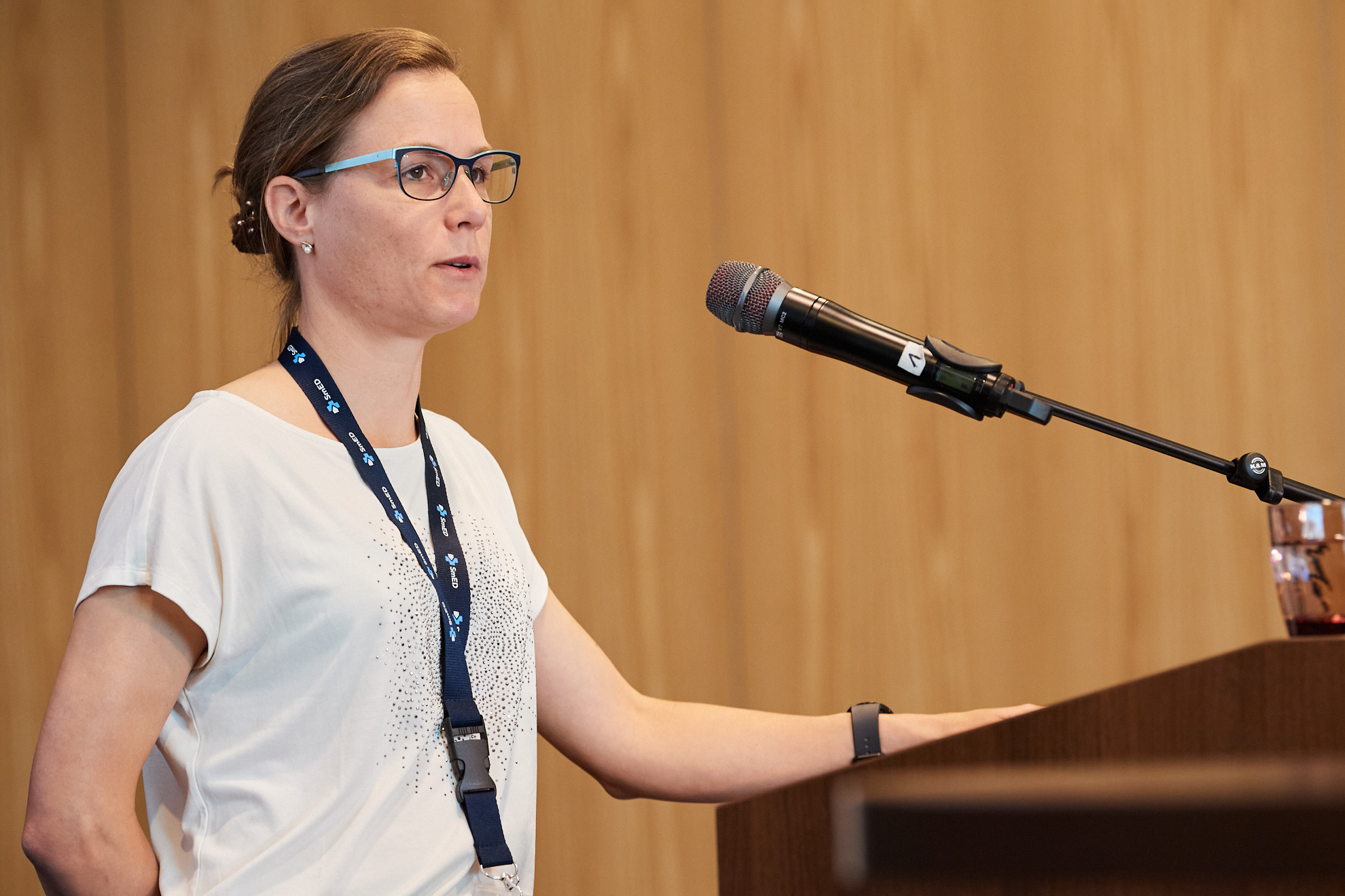 Eine Frau präsentiert Inhalte auf einer Konferenzbühne.