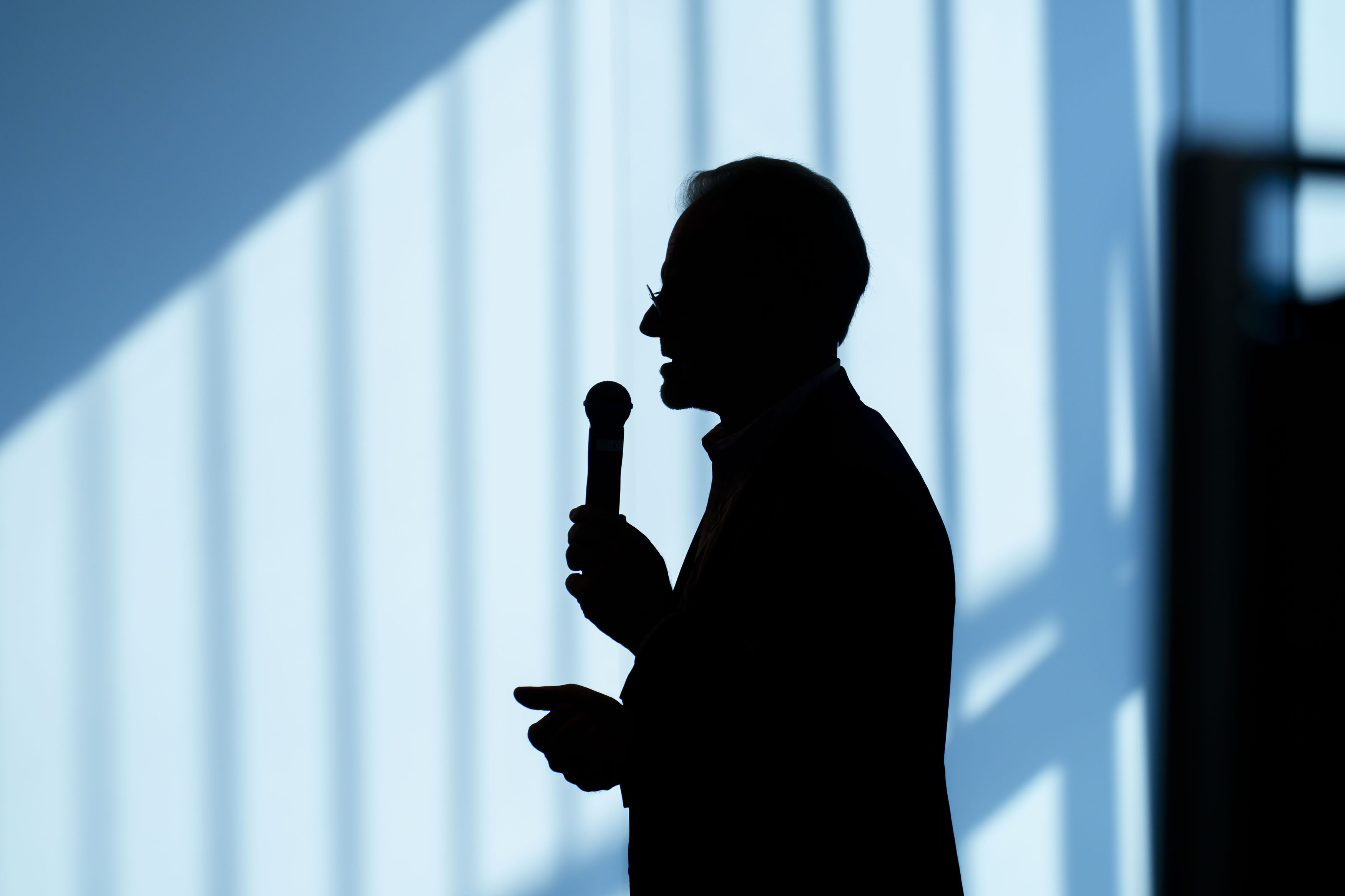Silhouette eines Sprechers mit Mikrofon