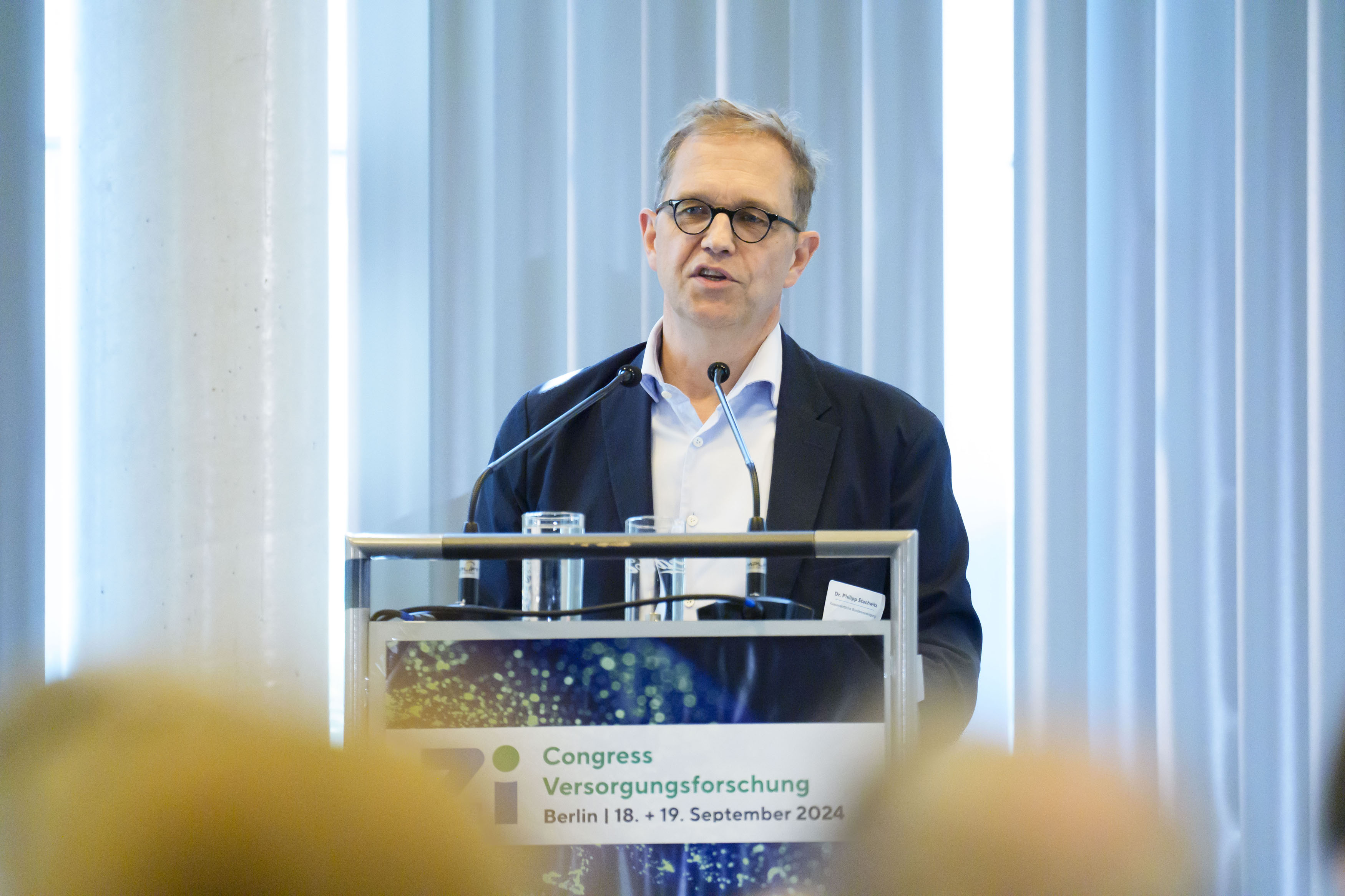 Redner am Podium während eines Vortrags