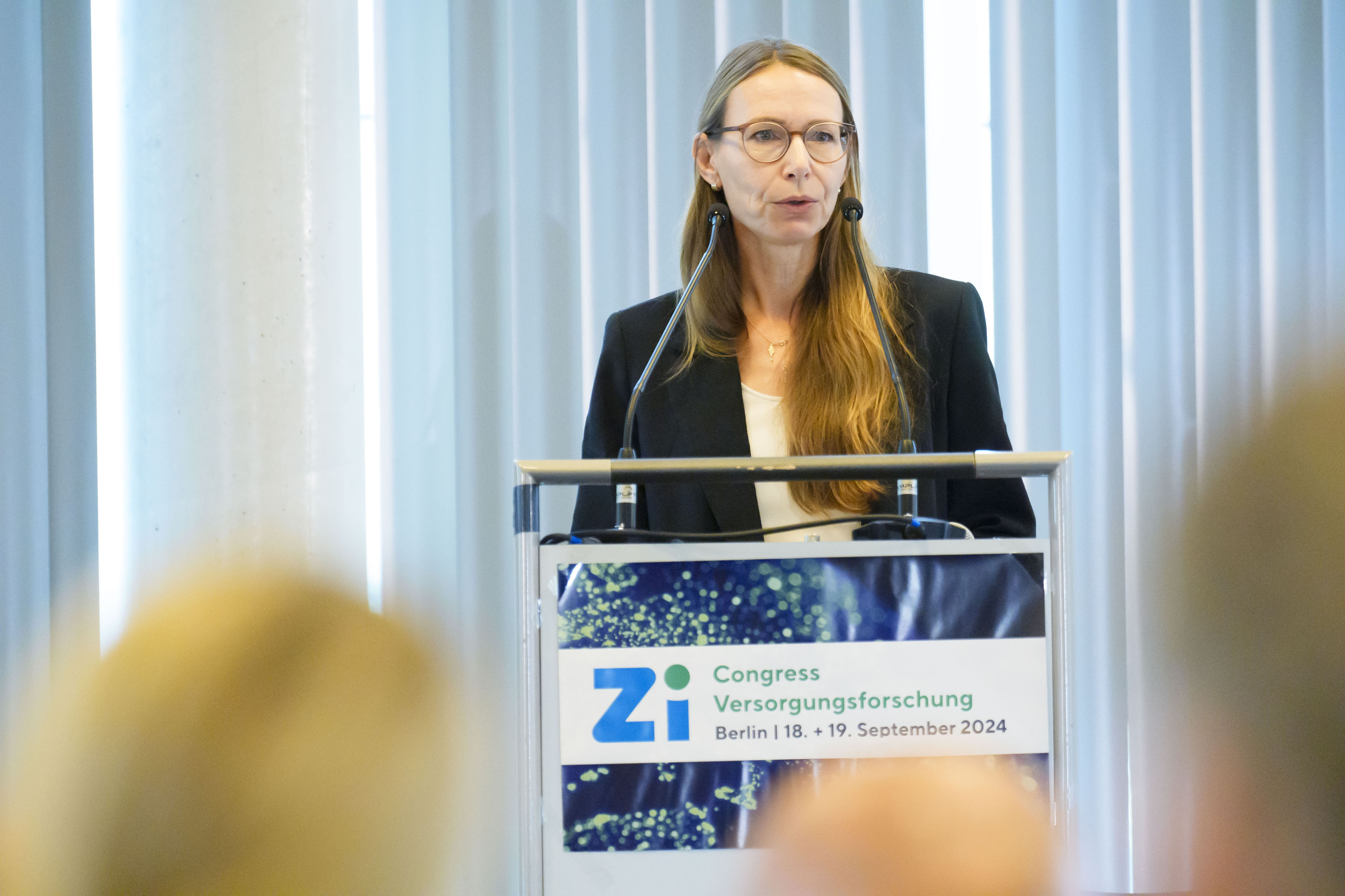 Rednerin am Podium während eines Vortrags