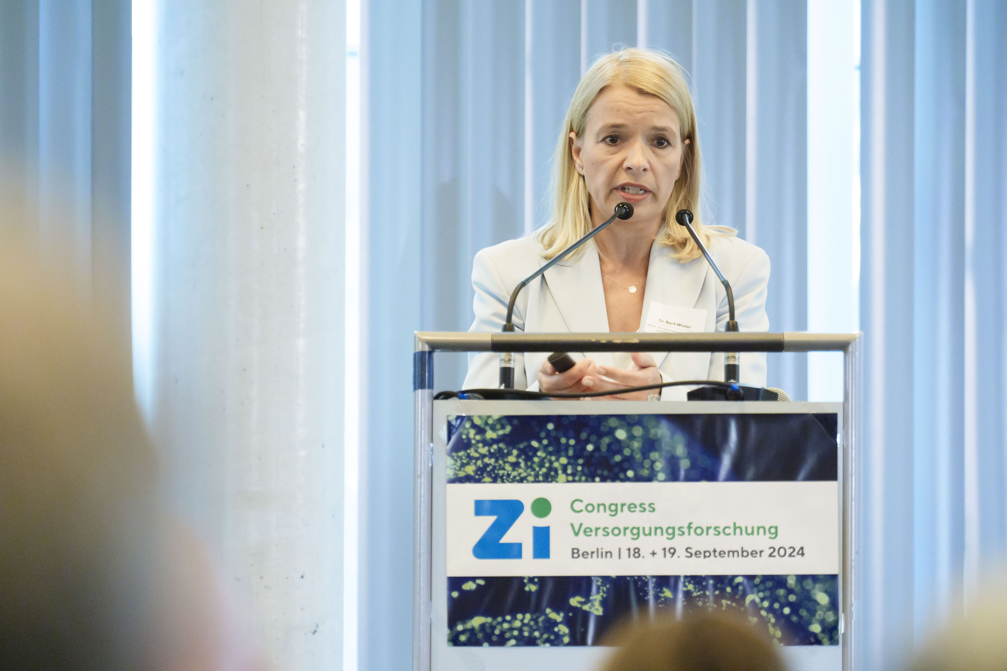 Rednerin am Podium während eines Vortrags