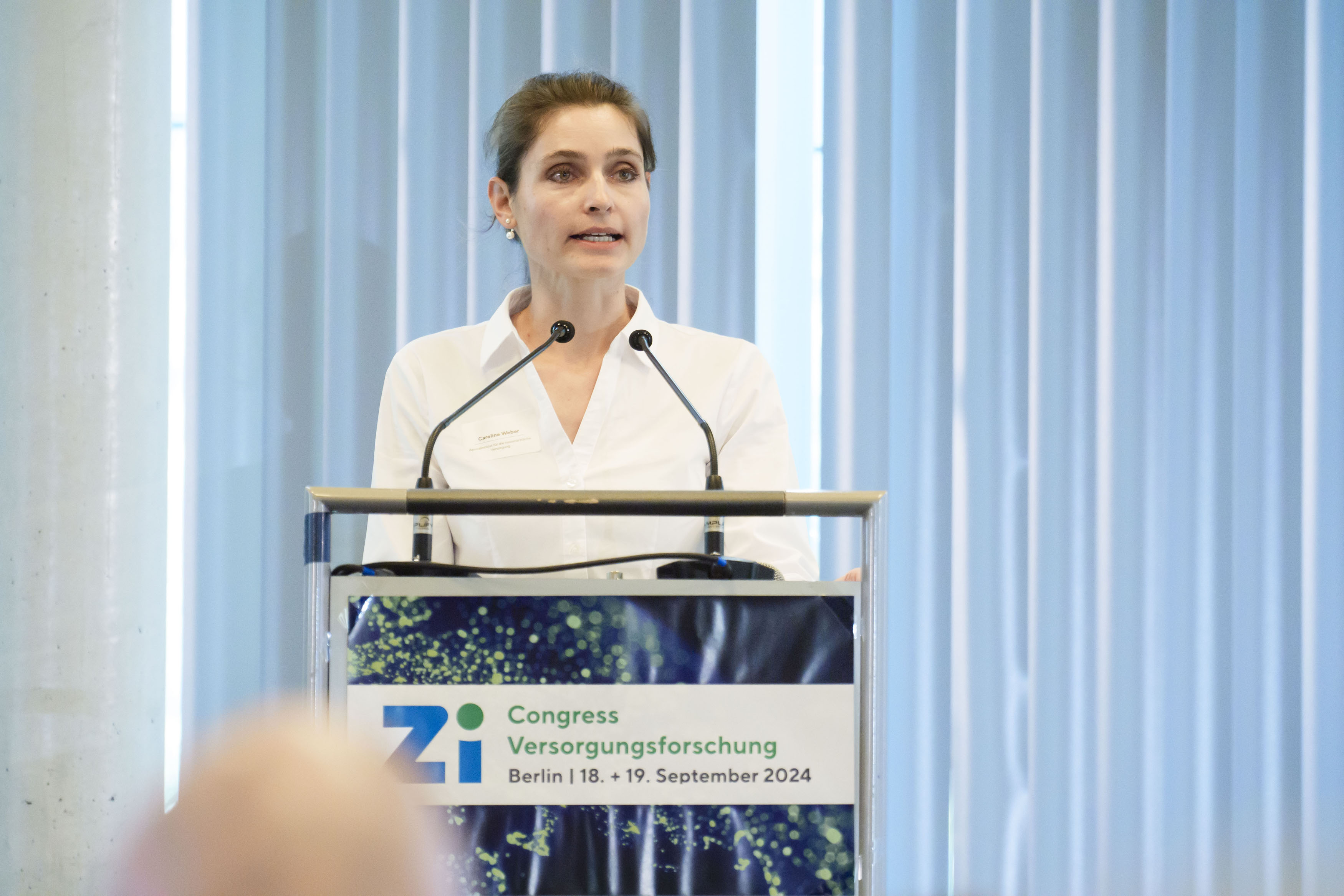 Rednerin am Rednerpult während eines Vortrags