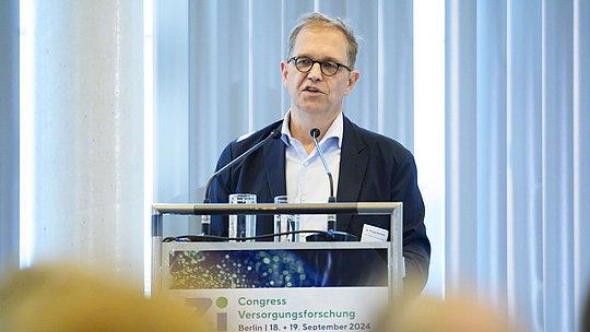 Redner am Podium während eines Vortrags