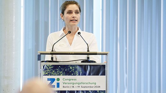 Rednerin am Rednerpult während eines Vortrags