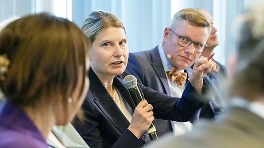 Podiumsteilnehmende gestikuliert während ihres Wortbeitrags