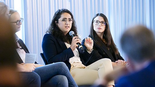 Podiumsteilnehmerin mit Handmikrofon während ihres Wortbeitrags