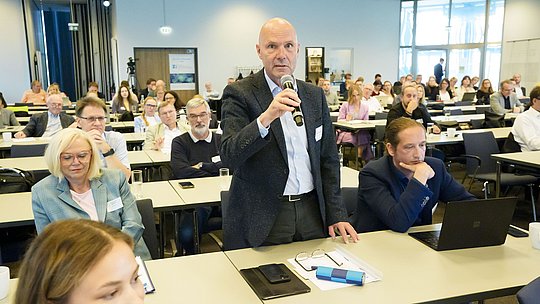 Teilnehmer aus dem Publikum stellt Rückfrage
