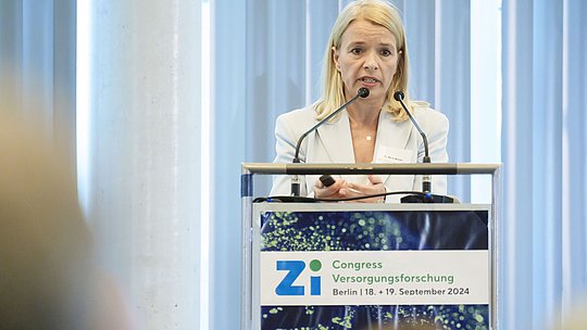 Rednerin am Podium während eines Vortrags