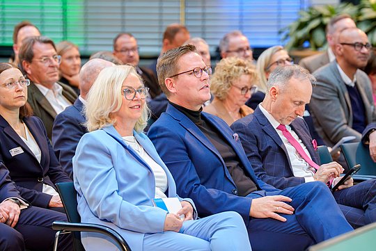 Dr. Annette Rommel, Staatssekretär Tino Sorge und Dr. Stephan Hofmeister in der ersten Reihe des Publikums.