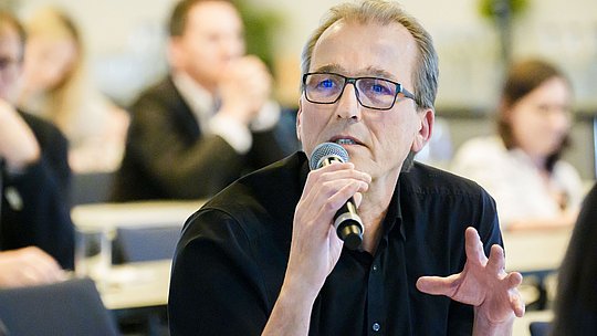 Teilnehmer aus dem Publikum stellt Rückfrage