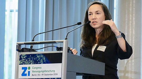 Rednerin am Rednerpult während eines Vortrags