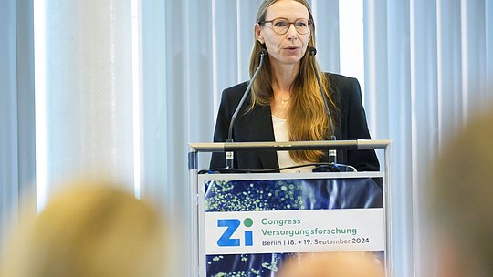 Rednerin am Podium während eines Vortrags